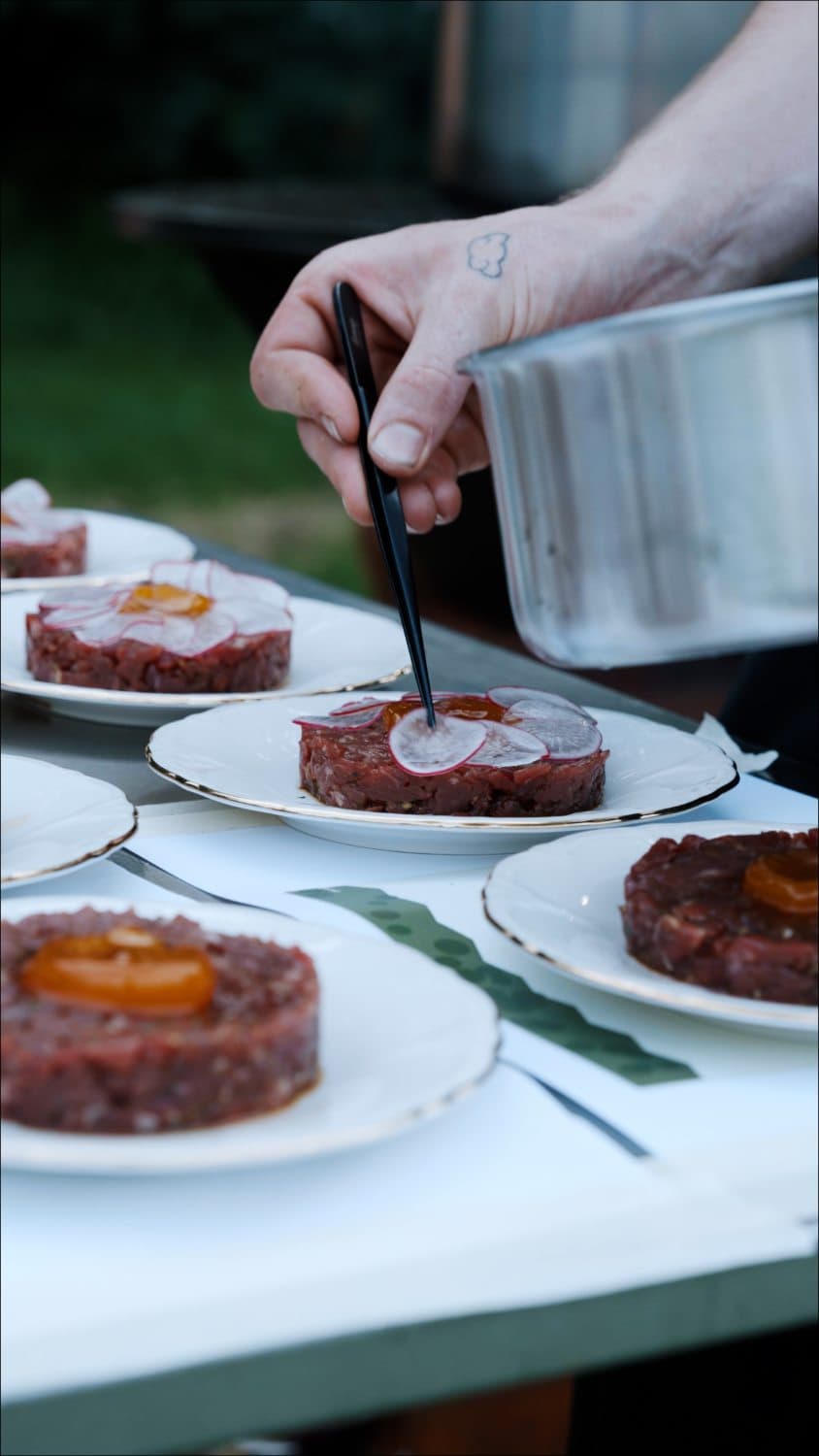 Kok werkt met een pincet aan de afwerking van een gerecht