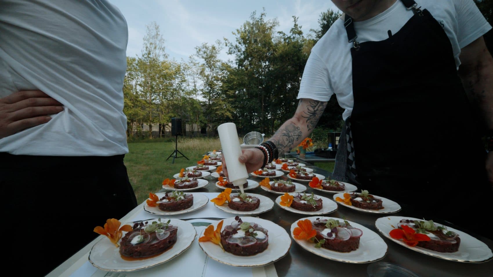 Reeks borden met rundertartaar en eetbare bloemen klaar om te serveren