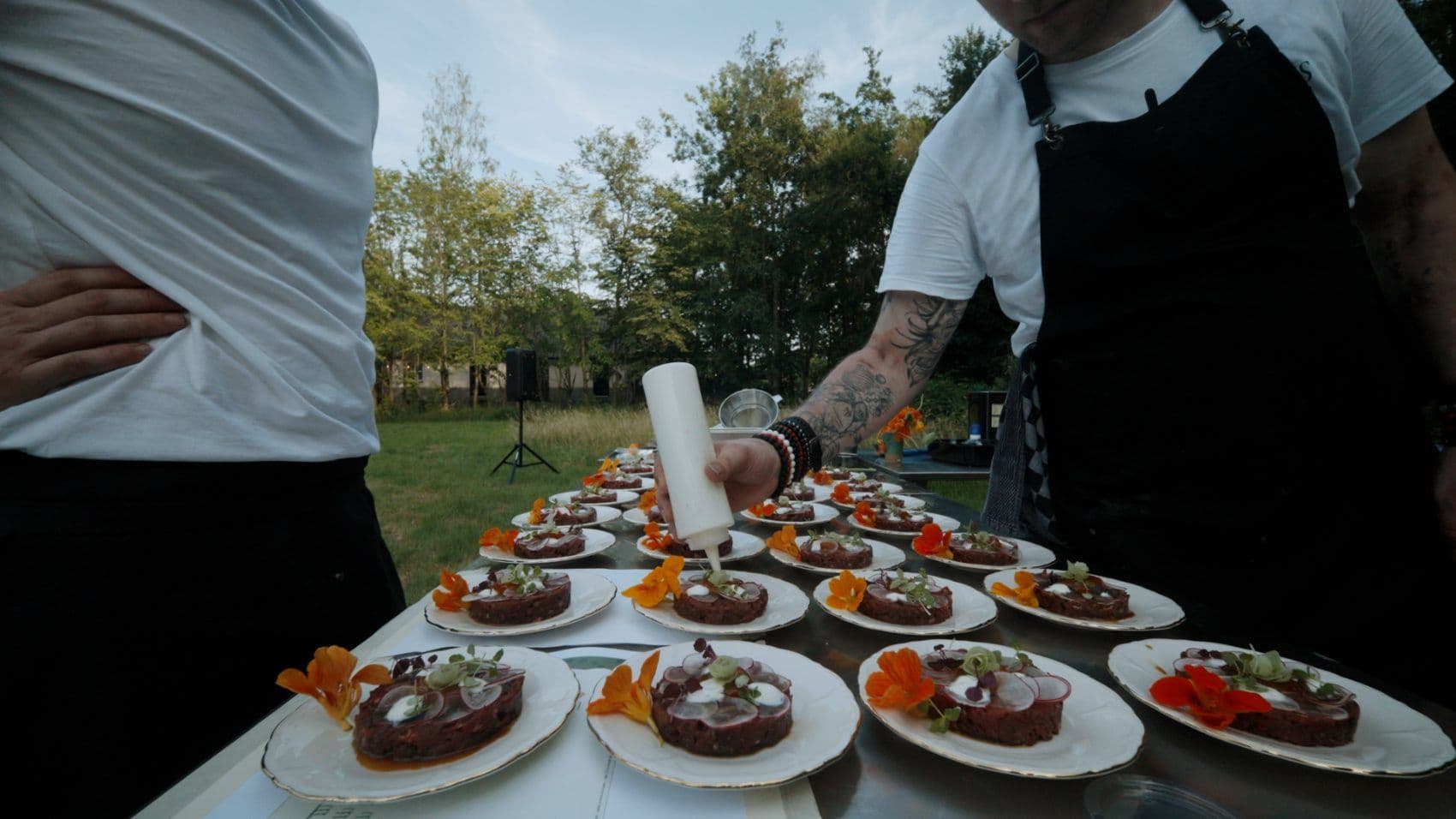 Reeks borden met rundertartaar en eetbare bloemen klaar om te serveren