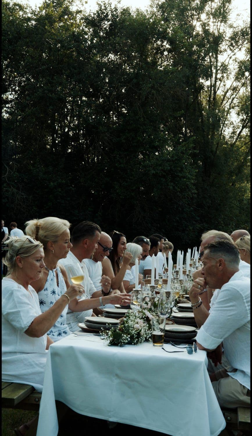 Gedekte tafel bij kaarslicht tijdens een diner in de open lucht